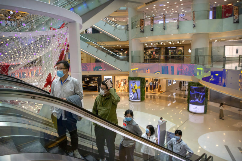 ***HOLD FOR CHINA GDP STORY***In this April 15, 2020 photo, people wear facemasks to protect against the spread of the new coronavirus cleans as they ride an escalator at a shopping mall in Beijing. (AP Photo/Mark Schiefelbein)