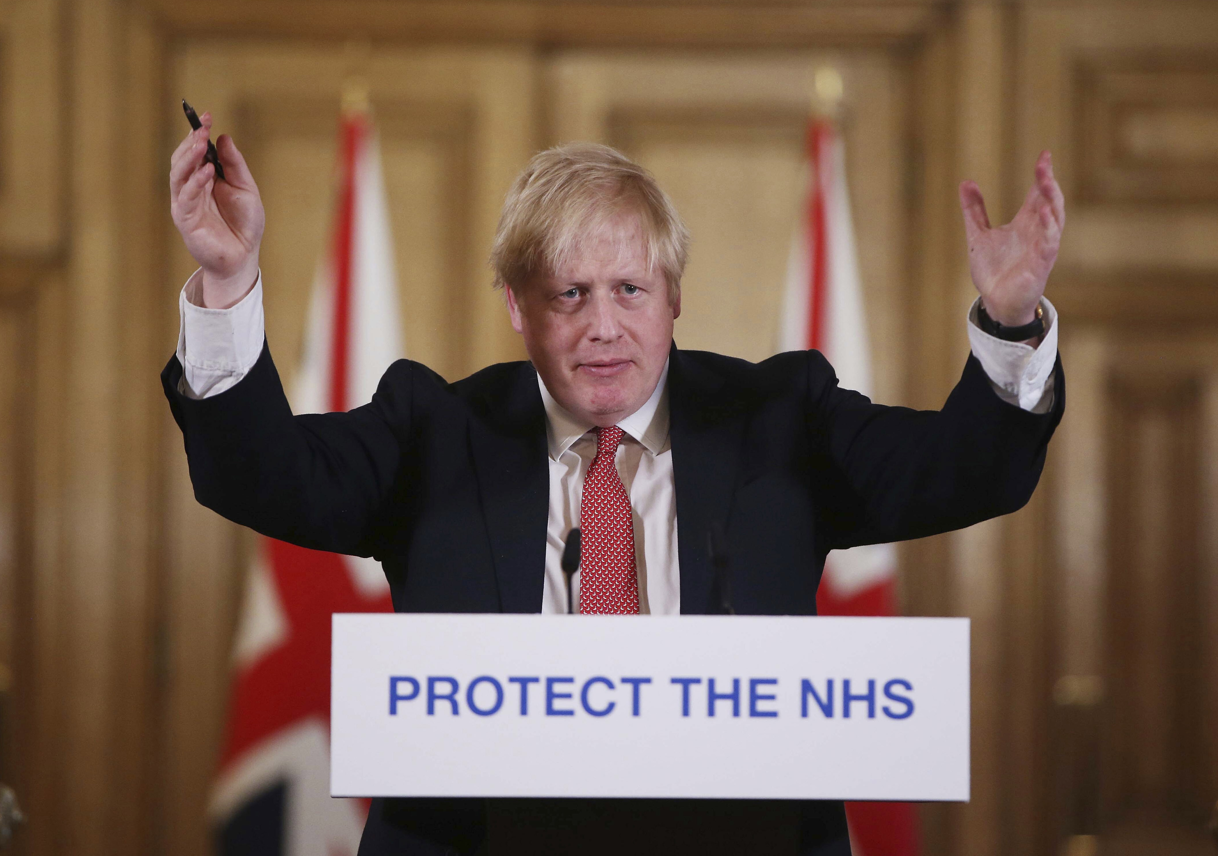 FILE - In this Sunday March 22, 2020 file photo British Prime Minister Boris Johnson gestures during his daily COVID 19 coronavirus press briefing to announce new measures to limit the spread of the virus, at Downing Street in London. The British prime minister’s office says Boris Johnson will return to work Monday April 27, 2020, two weeks after he was discharged from a London hospital where he was treated for the new coronavirus. (Ian Vogler / Pool via AP, File)