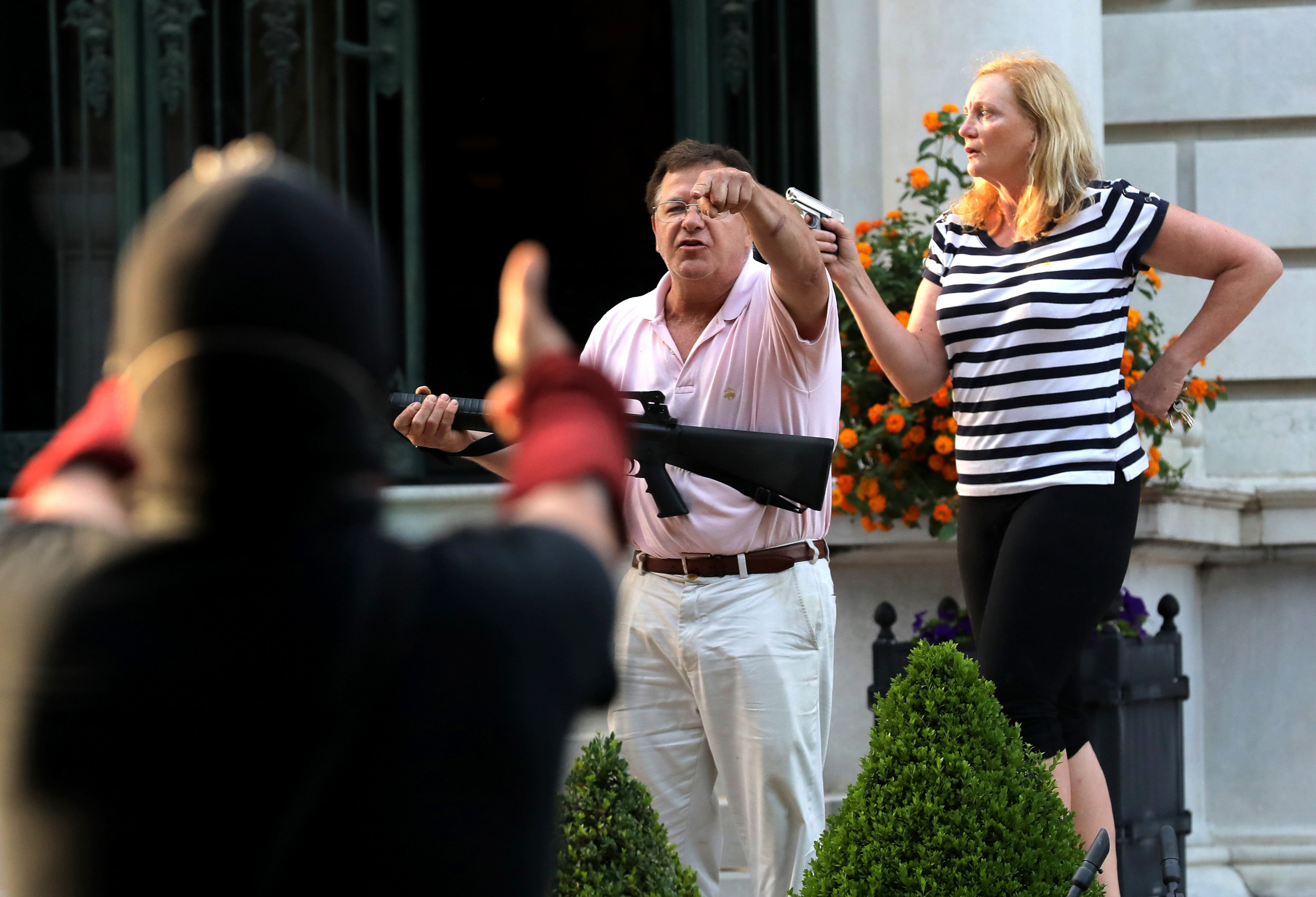 Armed homeowners standing in front of their house along Portland Place confront protesters as they march to Mayor Lyda Krewson's house on Sunday, June 28, 2020, in the Central West End in St. Louis. (Laurie Skrivan/St. Louis Post-Dispatch/TNS)