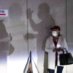 A woman waits to vote, Monday, Oct. 19, 2020, in Miami. Florida begins in-person early voting in much of the state Monday. With its 29 electoral votes, Florida is crucial to both candidates in order to win the White House. (AP Photo/Lynne Sladky)
