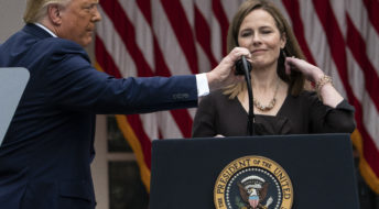 President Donald Trump adjusts the microphone after he announced Judge Amy Coney Barrett as his nominee to the Supreme Court, in the Rose Garden at the White House, Saturday, Sept. 26, 2020, in Washington. (AP Photo/Alex Brandon)