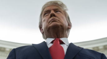 President Donald Trump listens during a ceremony to present the Presidential Medal of Freedom to former football coach Lou Holtz, in the Oval Office of the White House, Thursday, Dec. 3, 2020, in Washington. (AP Photo/Evan Vucci)