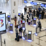 Travelers wait to check-in for their flights at LaGuardia Airport, Wednesday, Nov. 25, 2020, in the Queens borough of New York. Millions of Americans are taking to the skies and hitting the road ahead of Thanksgiving at the risk of pouring gasoline on the coronavirus fire. They are disregarding increasingly dire warnings that they stay home and limit their holiday gatherings to members of their own household. (AP Photo/John Minchillo)