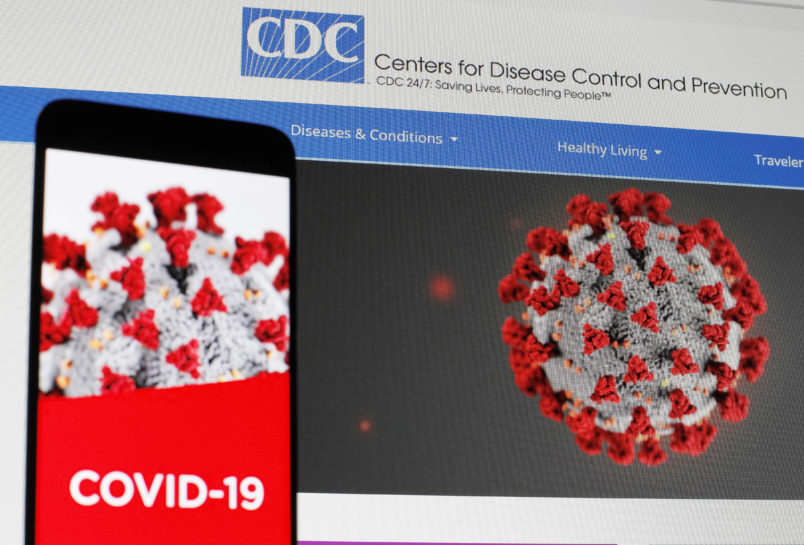UKRAINE - 2020/04/29: In this photo illustration the Centers of Disease Control and Prevention (CDC) web page displayed in internet on a pc screen and a coronavirus image on a mobile phone.The number of the COVID-19 coronavirus confirmed cases in the United States exceeded one million and exceeded three million in the world, according of COVID-19 Dashboard by the Center for Systems Science and Engineering (CSSE) at Johns Hopkins University (JHU). The World Health Organization declared the coronavirus a global pandemic on 11 March 2020. (Photo Illustration by Pavlo Gonchar/SOPA Images/LightRocket via Getty Images)