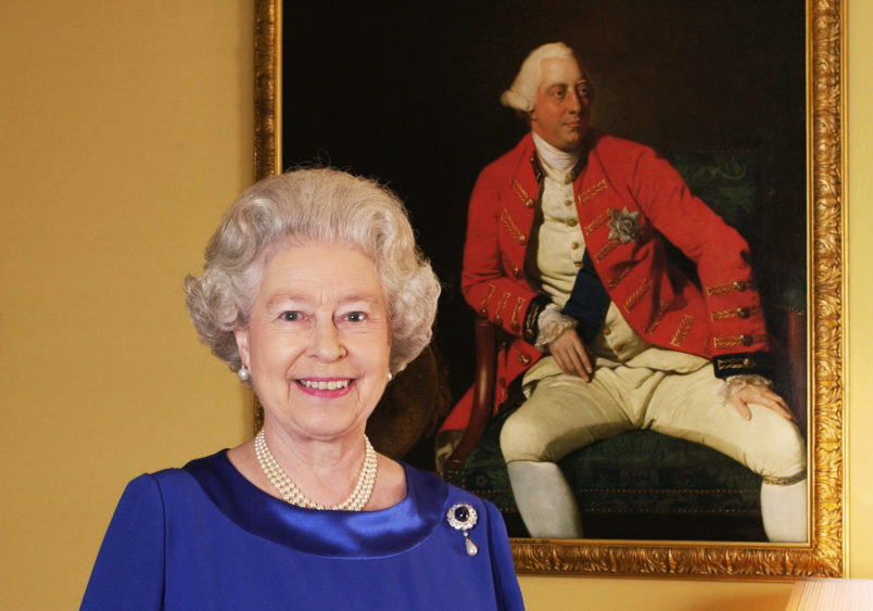 Queen Elizabeth II stands in the 18th Century Room at Buckingham Palace in front of a 1771 portrait by Johann Zoffany of George III, who was king for 59 years (1760-1820). * This photograph is one of a Golden Jubilee portfolio of photographs being unveiled to mark the 50th anniversary of the Queen's accession. The 18th Century Room is part of the Belgian Suite, used by visiting VIPs at Buckingham Palace - the official London residence of Queen Elizabeth II. 31/05/02 Photographers including the Earl of Lichfield and the rock star Bryan Adams were gathering today to see their Golden Jubilee portraits of the Queen go on public display.Seven photographers were scheduled to attend the National Portrait Gallery n London ahead of a free exhibition to mark the monarch's 50 years on the throne. (Photo by Fiona Hanson - PA Images/PA Images via Getty Images)