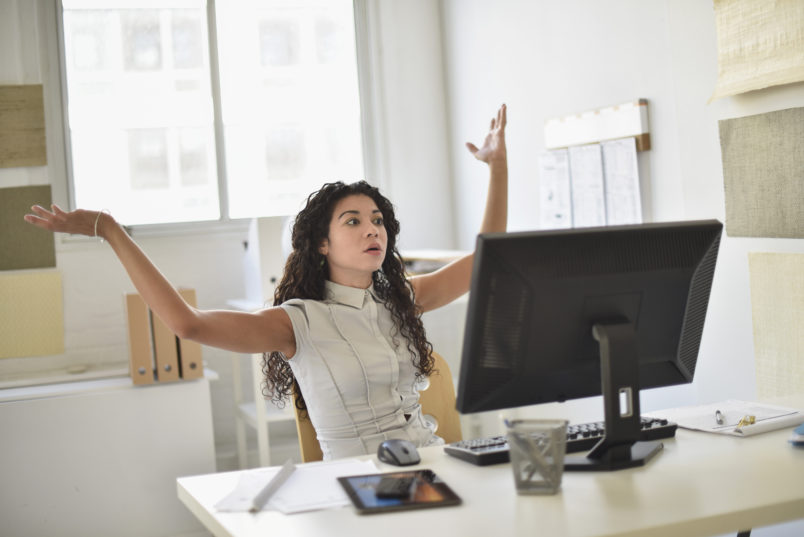 Businesswoman frustrated at computer at desk in office