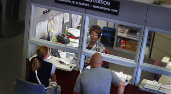 MIAMI, FL - OCTOBER 01:  Dorothy Torrence, from the Miami-Dade Elections Department, helps Yarelis Alvarez (L) and Alberto Alvarez fill out their voter registration forms on October 1, 2012 in Miami, Florida. As the October 9th deadline for people to register to vote in the upcoming election approaches according to the Florida Department of State, the number of people registering to vote is now averaging between 1,500 and 3,000 a day. After months of the Democrats questioning the motives of the Republican led legislator to purge non citizens and roll back early voting, the Republican Party was accused of using a firm to register voters that was providing false voter registration information. (Photo by Joe Raedle/Getty Images)